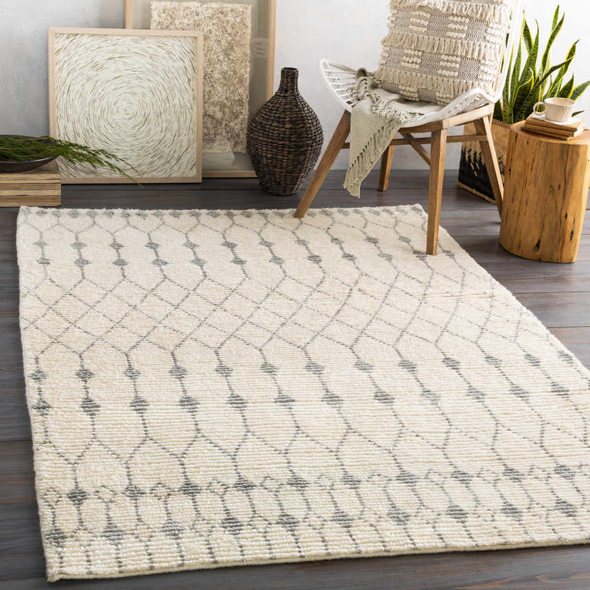 Farmhouse living room scene with ivory and gray Pooleville Area Rug, wood floors, chair, and neutral decor. Roomscene-Rectangle