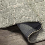Close-up of the hand-tufted Posof Area Rug. Light beige and gray wool rug with a contemporary geometric pattern. Fold