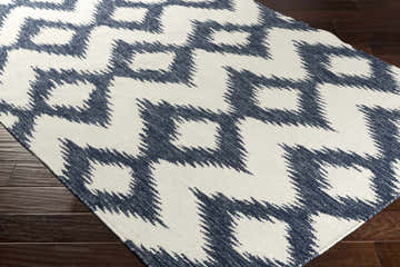 Close-up of the Prairie Area Rug, a cream and navy wool rug with a geometric, contemporary pattern. Corner
