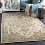 Living room scene with Broomfield Hand Tufted Sage 1143 Area Rug, blue armchair, and dark wood floors. Roomscene-Rectangle