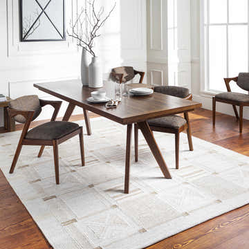 Dining room with a Pearcedale Area Rug in beige, cream, and tan under a wood table and chairs. Roomscene-Rectangle