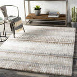 Living room scene with Prees Area Rug in cloud gray, cream, and brown. Contemporary style with metal chair and wood shelving. Roomscene-Rectangle