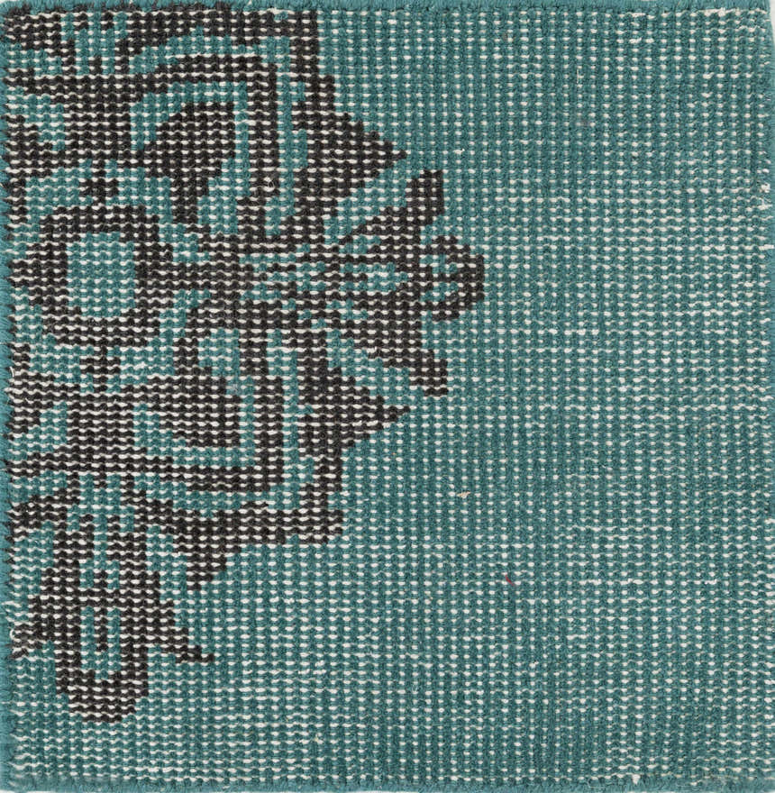 Close-up of the hand-knotted Presidio Area Carpet. Emerald wool rug with a black, contemporary floral pattern. Swatch