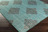 Close-up of the emerald and black Presidio Area Carpet showing its hand-knotted wool texture and geometric pattern. Corner