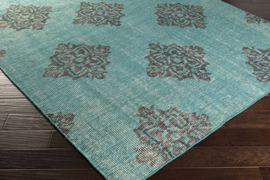 Close-up of the emerald and black Presidio Area Carpet showing its hand-knotted wool texture and geometric pattern. Corner