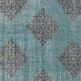 Close-up of Presidio Area Carpet. Emerald wool rug with a traditional black diamond medallion pattern. Hand-knotted texture. Swatch