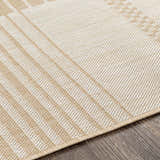 Close-up of the Portscatho Carpet. Beige and light beige tones with a subtle geometric pattern and woven texture. Texture