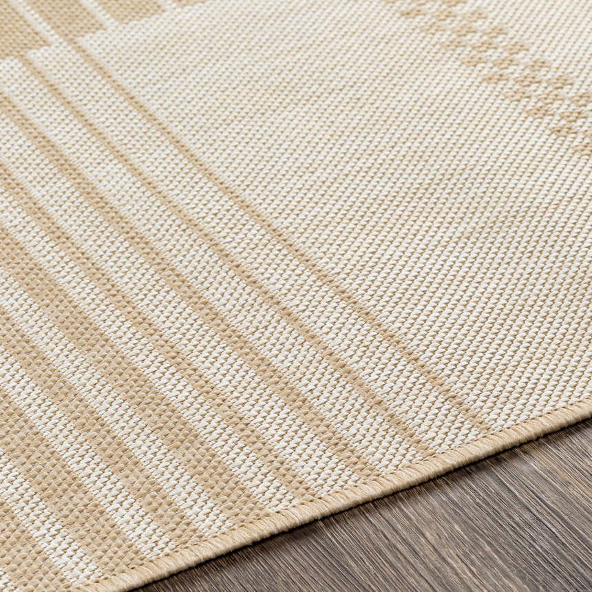 Close-up of the Portscatho Carpet. Beige and light beige tones with a subtle geometric pattern and woven texture. Texture