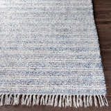 Close-up of the hand-loomed Potterspury Area Rug showing blue, cream, and gray woven texture and fringe detail. Front