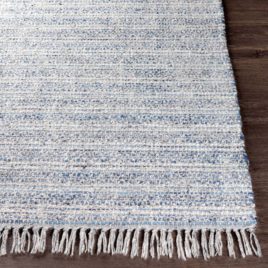 Close-up of the hand-loomed Potterspury Area Rug showing blue, cream, and gray woven texture and fringe detail. Front