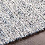 Close-up of the hand-loomed Potterspury Area Rug. Blue, cream, and gray wool and polyester fibers create a textured, contemporary design. Texture