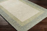 Close-up of the hand-tufted Pualas Area Rug. Cream, sage, and beige stripes on a textured 100% wool rug. Corner