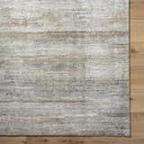 Close-up of the Agueda Thick Luxe Rug showing beige, tan, light gray, and olive striations on a wood floor. Corner