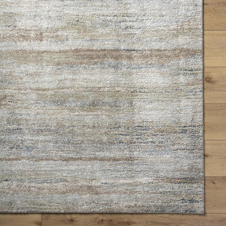 Close-up of the Agueda Thick Luxe Rug showing beige, tan, light gray, and olive striations on a wood floor. Corner