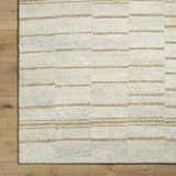 Close up of the Abbatha Modern Wool Rug showing beige and tan horizontal stripes on a textured background. Corner