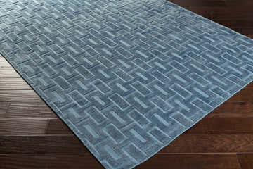 Close-up of the blue Quealy Viscose Rug featuring a geometric, raised pattern and a soft, textured feel. Corner