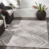 Bohemian patio with wicker chairs and the geometric black and white Queanbeyan Area Rug. Roomscene-Rectangle