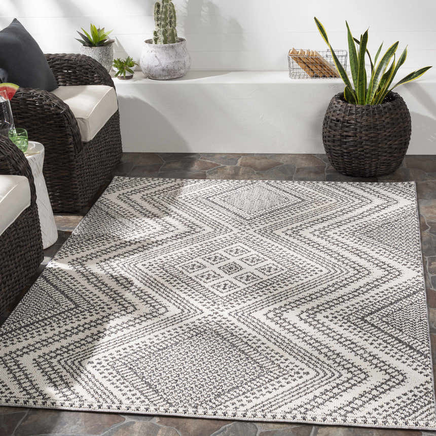 Bohemian patio with wicker chairs and the geometric black and white Queanbeyan Area Rug. Roomscene-Rectangle