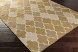 Close-up of the hand woven Quebeck Area Carpet. Features a contemporary quatrefoil pattern in cream, sage, gray, brown, and tan. Corner