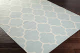 Close-up of the Ragan Ice Blue Trellis Cotton Rug showing the ice blue and cream geometric pattern and hand-woven texture. Corner