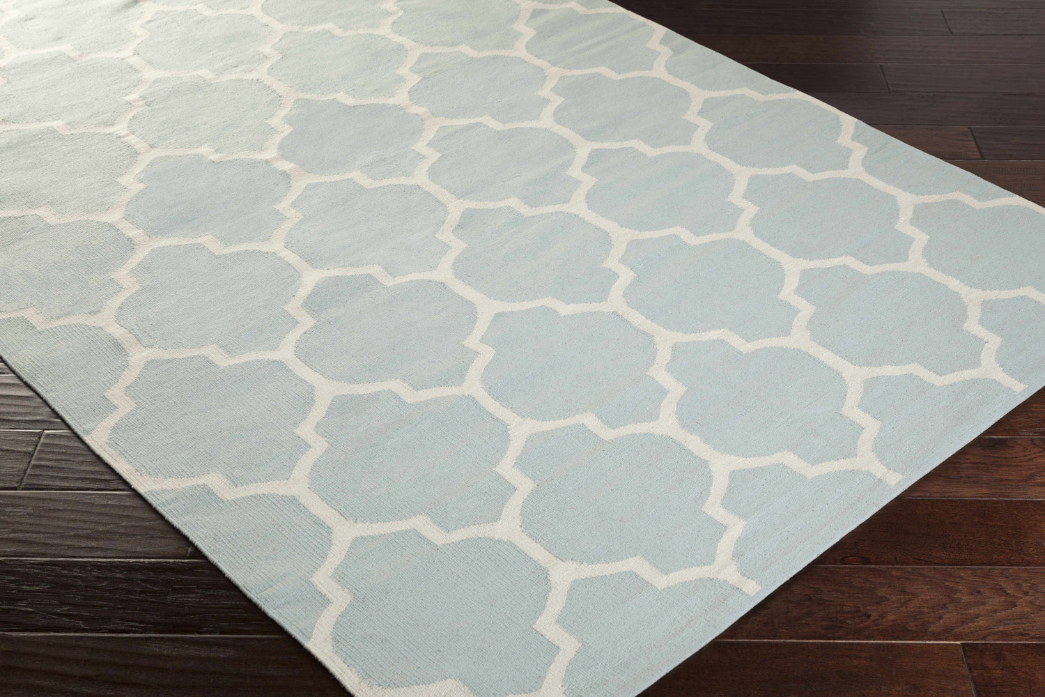 Close-up of the Ragan Ice Blue Trellis Cotton Rug showing the ice blue and cream geometric pattern and hand-woven texture. Corner