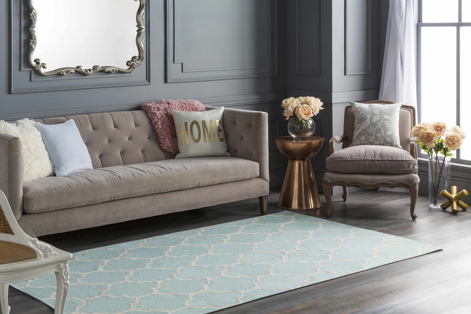 Living room scene with a Ragan Ice Blue Trellis Cotton Rug, gray walls, and a tufted sofa with decorative pillows. Roomscene-Rectangle