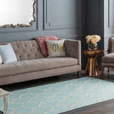 Living room scene with a Ragan Ice Blue Trellis Cotton Rug, taupe sofa, copper accent table, and gray walls. Roomscene-Rectangle
