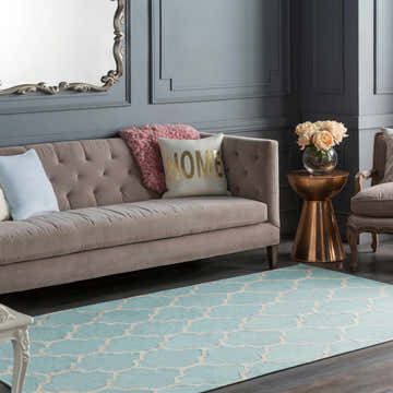 Living room scene with a Ragan Ice Blue Trellis Cotton Rug, taupe sofa, copper accent table, and gray walls. Roomscene-Rectangle