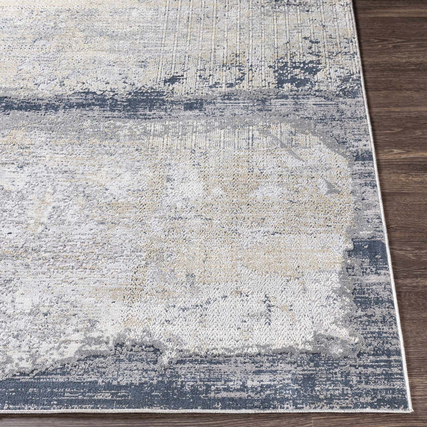 Close-up of the Rainworth Modern Slate Luxe Rug, showing charcoal, beige, and blue abstract pattern and machine-woven texture. Front
