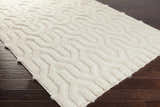 Close up of a cream Ransom Area Rug showing the shag texture and geometric pattern. Corner