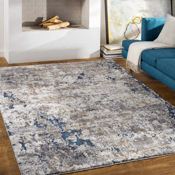 Living room with blue sofa and Ratho Rock Pattern rug in ivory, gray, tan, and blue. Roomscene-Rectangle