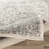 Close-up of the Rockfall Area Rug showing its charcoal and gray traditional pattern and soft, textured pile. Fold