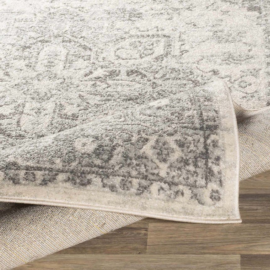 Close-up of the Rockfall Area Rug showing its charcoal and gray traditional pattern and soft, textured pile. Fold