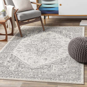 Living room scene with a gray Rockfall Area Rug, gray chair, and wood cabinet. Roomscene-Rectangle