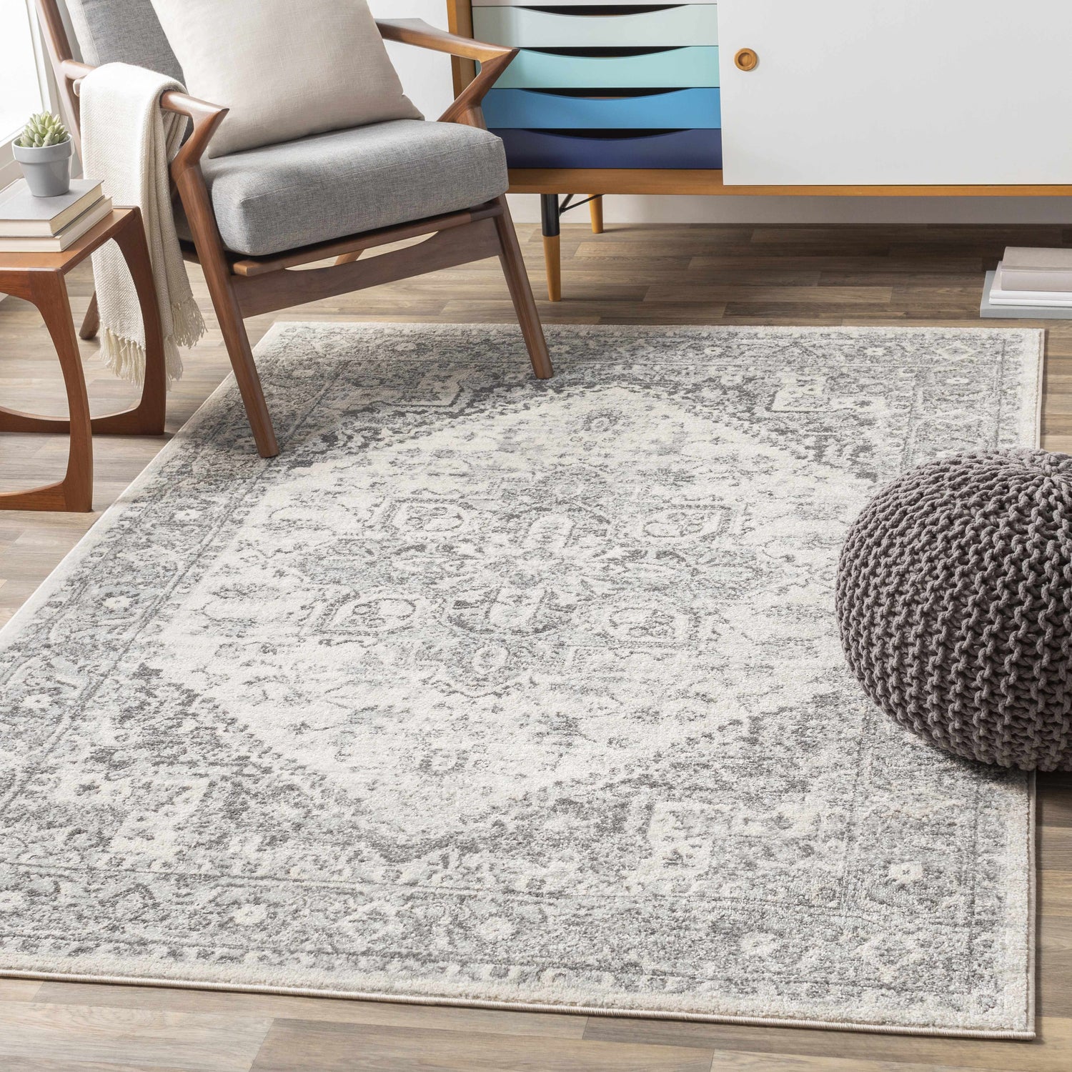 Living room scene with a gray Rockfall Area Rug, gray chair, and wood cabinet. Roomscene-Rectangle