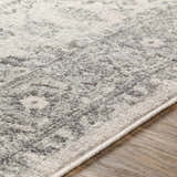 Close-up of the Rockfall Area Rug, showing a traditional gray, charcoal, and light beige pattern and soft texture. Texture