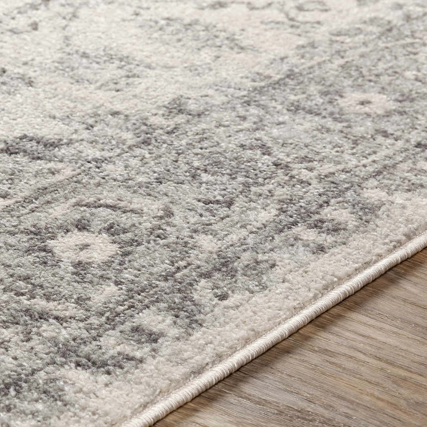 Close-up of the Rockfall Area Rug, showing a traditional gray, charcoal, and light beige pattern and soft texture. Texture