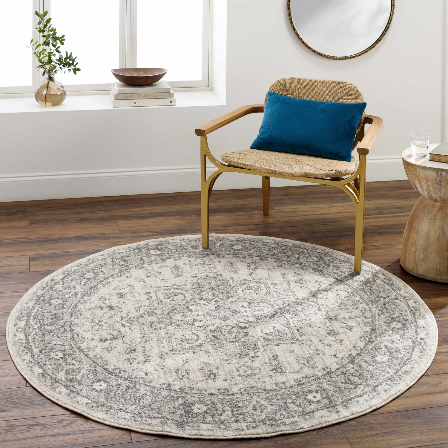 Living room scene with a round Rockfall Area Rug in charcoal and gray under a chair. Roomscene-Round