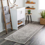 Bathroom scene with a gray Rockfall Area Rug, white vanity, wood accents, and plants. Roomscene-Runner