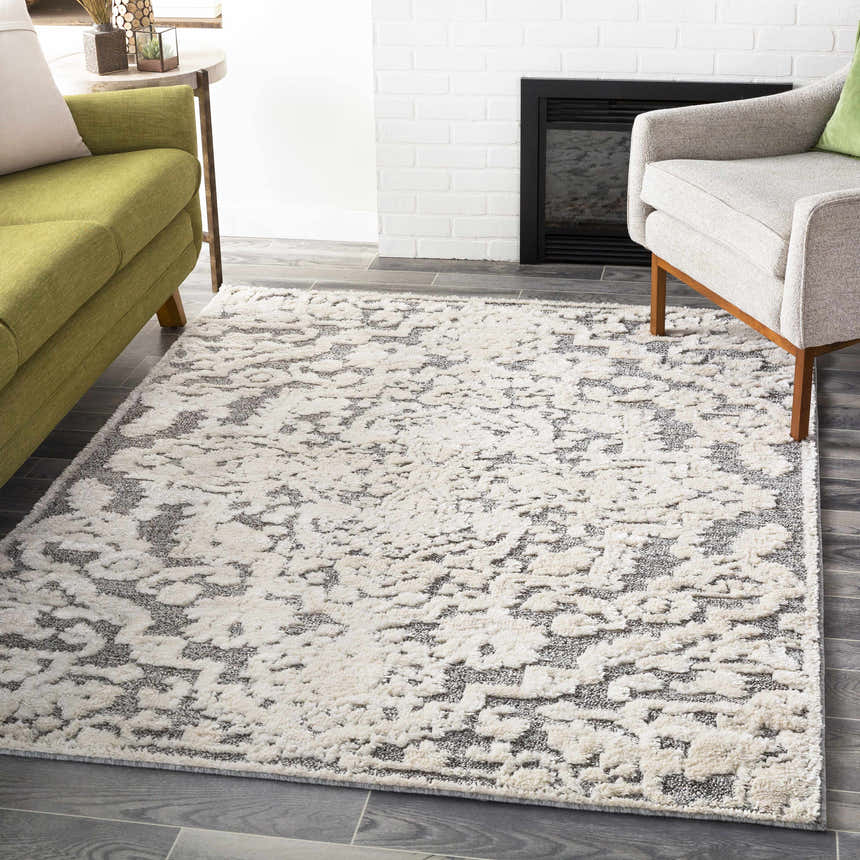 Living room scene with a Rockeagle Area Rug in beige, cream, and gray, styled with a green sofa and gray armchair. Roomscene-Rectangle