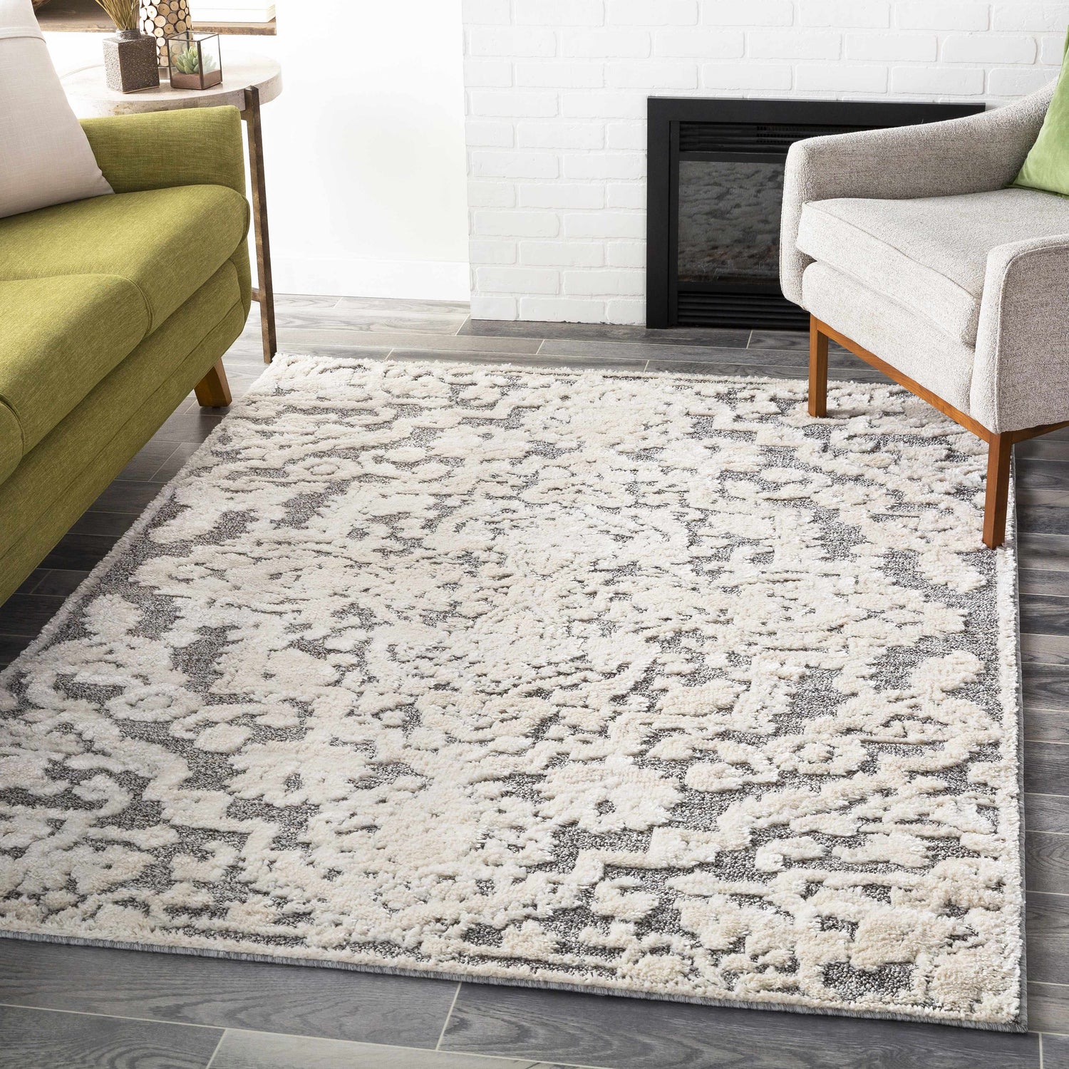 Living room scene with a Rockeagle Area Rug in beige, cream, and gray, styled with a green sofa and gray armchair. Roomscene-Rectangle