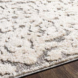 Close-up of the Rockeagle Area Rug. Beige and charcoal bohemian pattern with a soft, textured pile. Texture