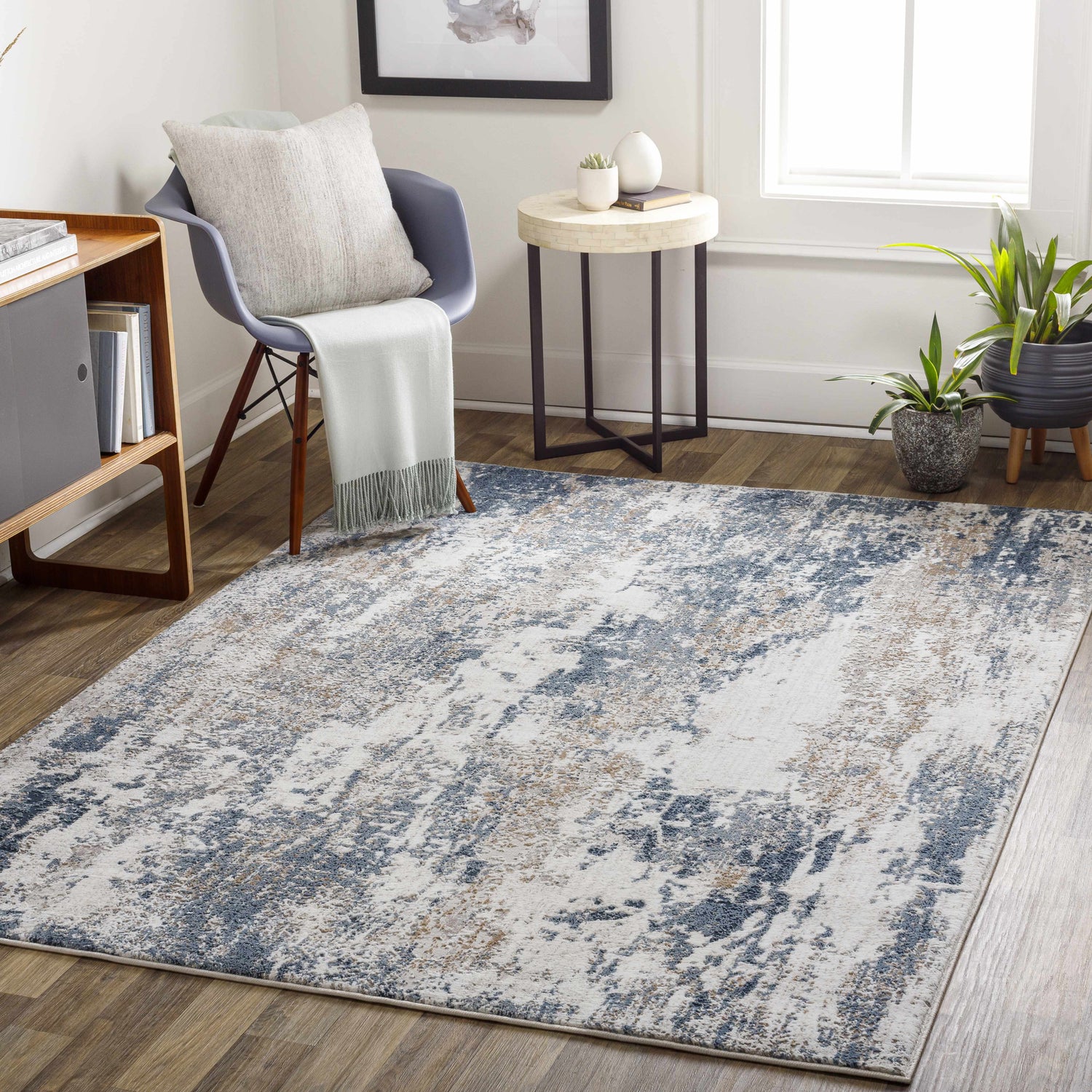 Living room scene with the Ord Area Rug in dark gray, denim, and ivory. Contemporary style with chair, table, and plants. Roomscene-Rectangle