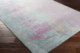 Close up of the Redland Colorful Abstract Rug showing its aqua, magenta, and gray hues on dark wood floors. Corner