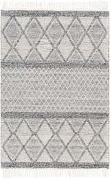 Close-up of the Rehn Area Rug featuring a geometric diamond pattern in dark gray, light gray, and taupe with fringe. Design-Rectangle-576