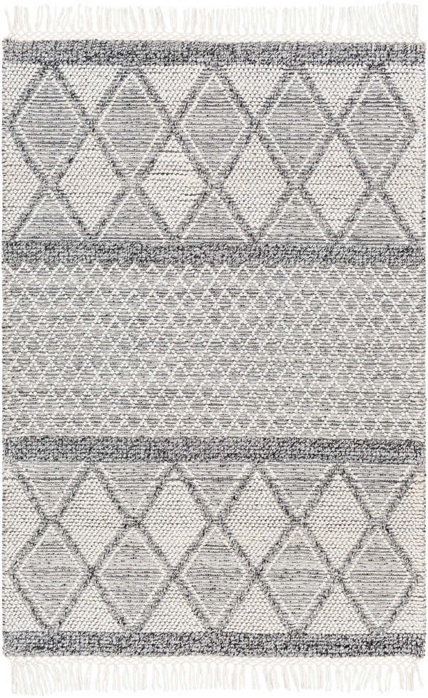 Close-up of the Rehn Area Rug featuring a geometric diamond pattern in dark gray, light gray, and taupe with fringe. Design-Rectangle-576