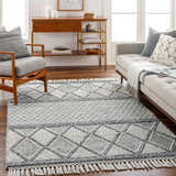 Living room scene with gray sofa, chair, and the Rehn Area Rug in dark gray, light gray, and taupe with a geometric pattern. Roomscene-Rectangle