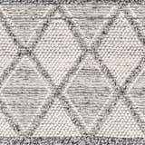 Close-up of the Rehn Area Rug, a hand-woven rug with a geometric pattern in dark gray, light gray, smoke, and taupe. Swatch