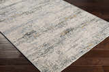 Close-up of the Rendlesham Luxe Rug. Contemporary design in cream, gray, and mustard tones on dark wood flooring. Corner