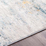 Close-up of the Rendlesham Luxe Rug showing cream, teal, and mustard colors with a contemporary abstract pattern. Texture